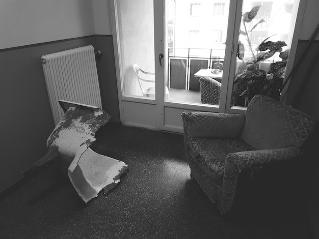 A black and white photograph of a room interior depicting the aftermath of suspected spontaneous human combustion, with a charred chair and minimal damage to the surrounding area.