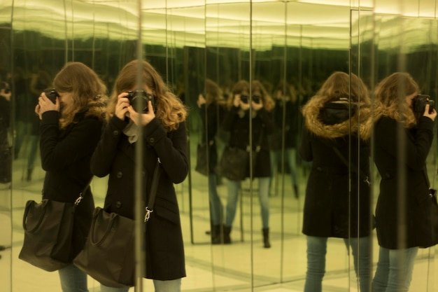 A series of blurred photographs, supposedly taken with a phone, showing mannequins in various positions within a shop window, with one appearing to be mid-step. The image quality is low and grainy.